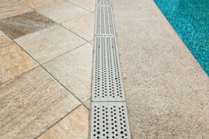 How can poor drainage affect an inground pool?